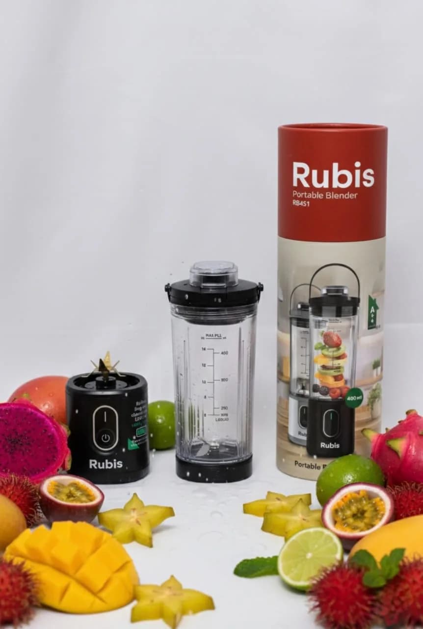 جعبه استوانه‌ای Rubis Portable Blender RB451 در کنار شیکر مشکی و میوه‌های تازه