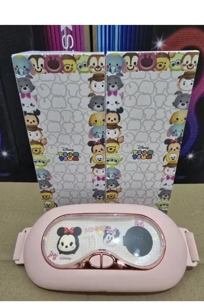 عکس واقعی از قفسه: دو جعبه خرده‌فروشی با چاپ شخصیت‌های Tsum Tsum و لوگوی Disney TSUM TSUM ایستاده‌اند و کمربند گرم‌کن صورتی جلوی آن‌ها روی سطح خوابیده است.