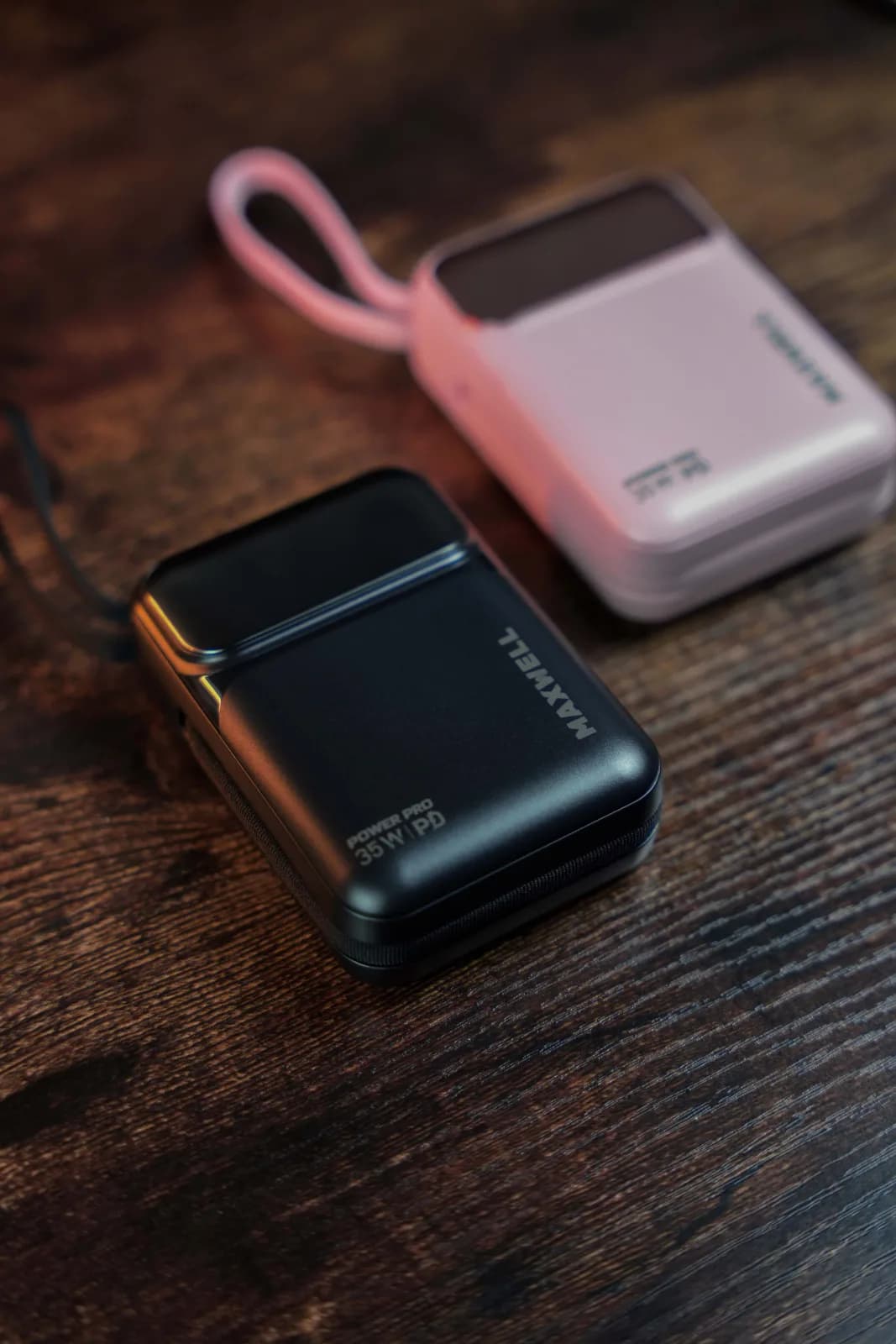 نمای نزدیک بدنه مشکی پاوربانک مکسول Power Pro 20000 با نوشته POWER PRO 35W PD روی میز چوبی؛ نمونه صورتی گوشه بالا فقط برای نمایش است و موجود نیست